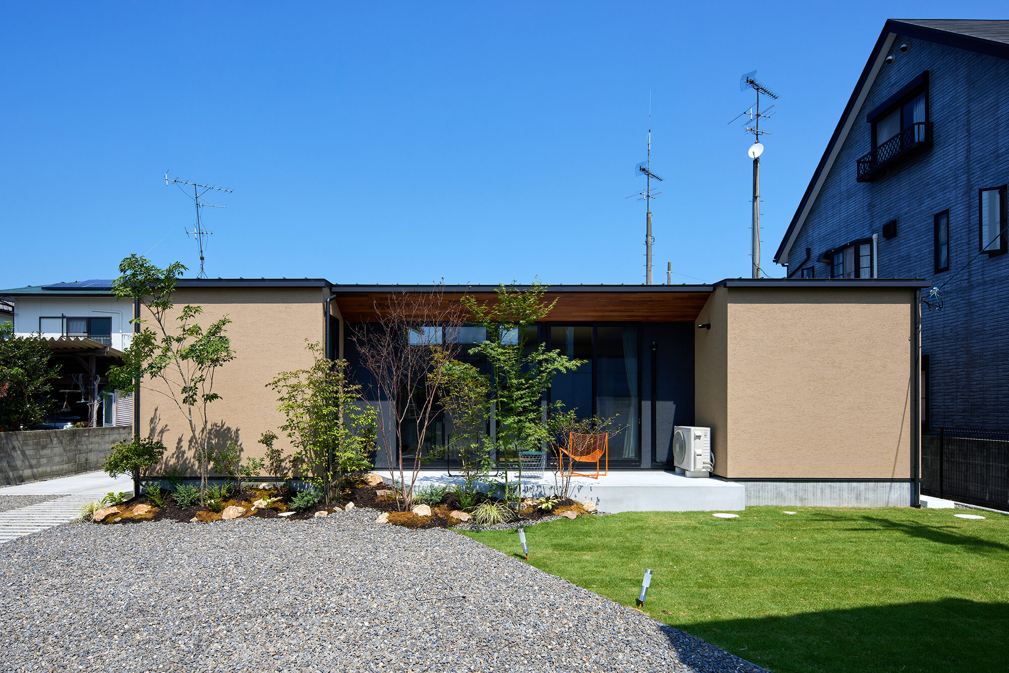 青空の下、芝生の庭に建つオーナー様邸の全景