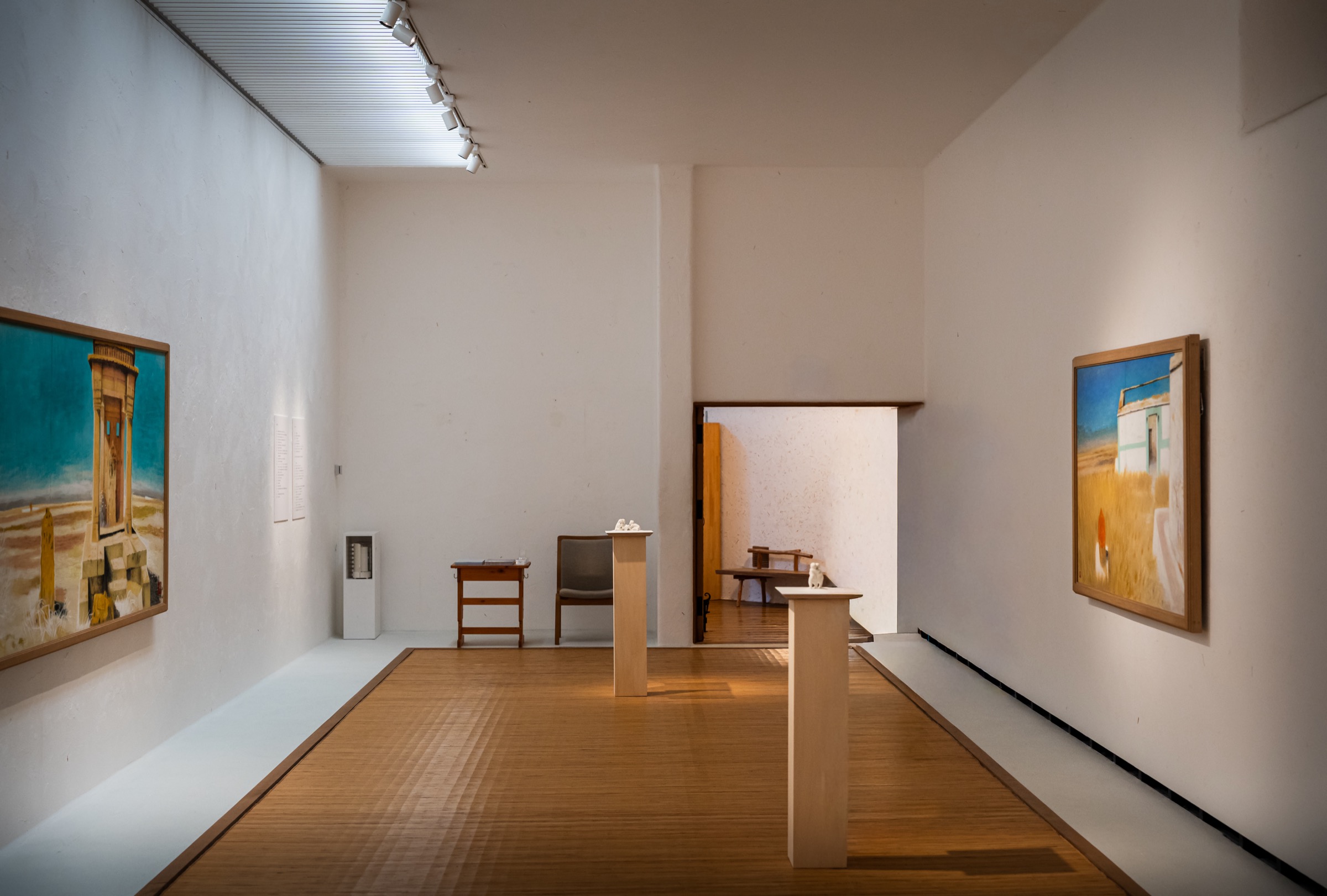 铺藤席的展廊里画作与白色台座上的雕塑并列(滨松市秋野不矩美术馆)