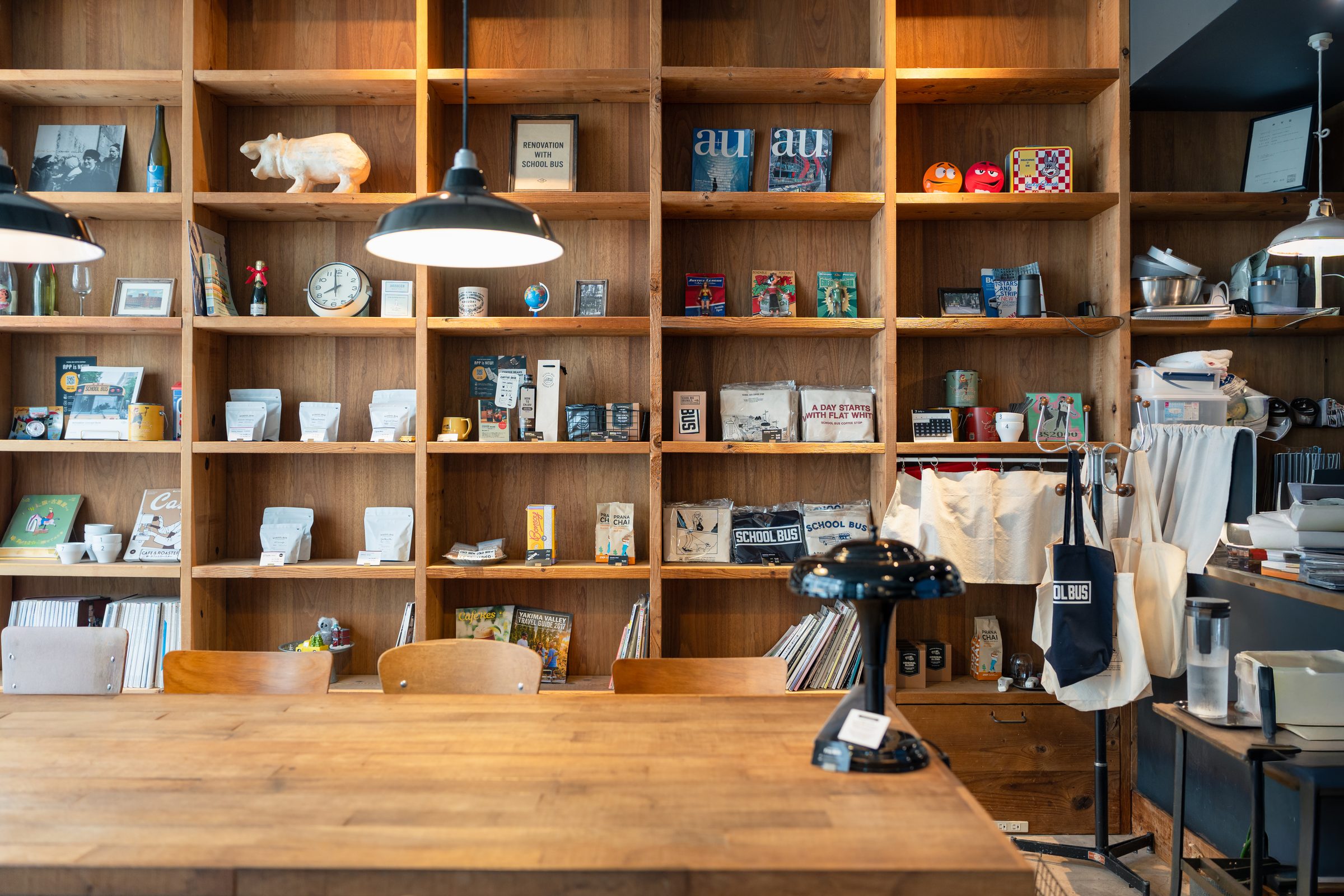 ヴィンテージの棚と長机が並ぶ店内(SCHOOL BUS COFFEE STOP キタハマ)