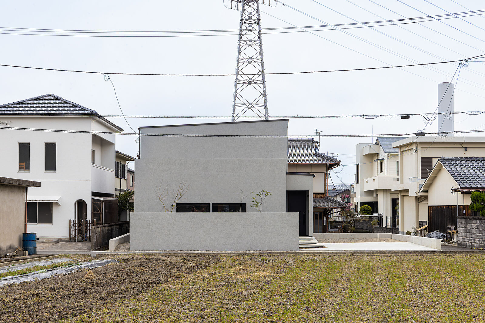 青空の下、白い箱を重ねたような外観の住宅