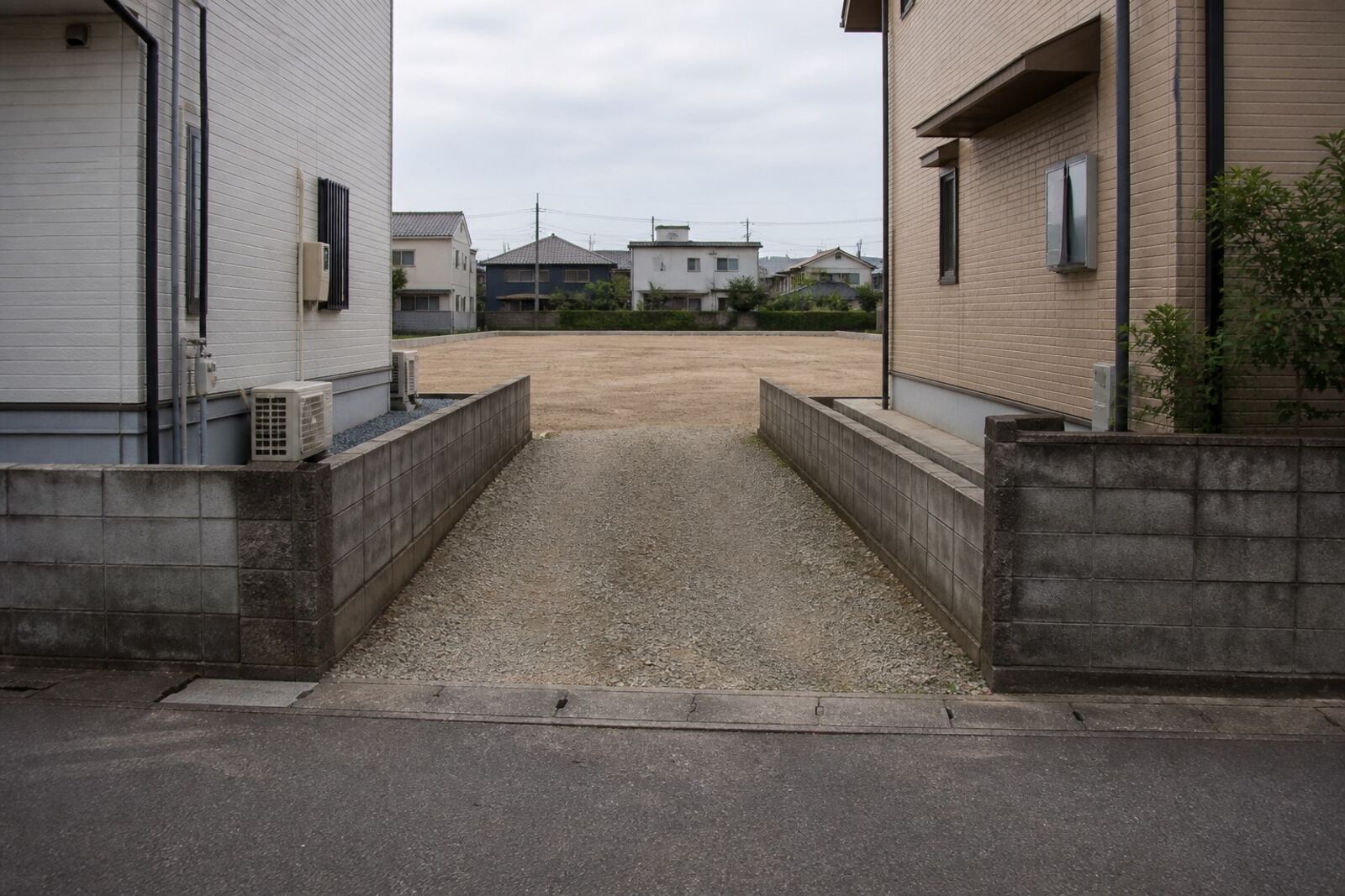 道路から細い通路が奥へ伸び、その先に敷地が広がる旗竿地