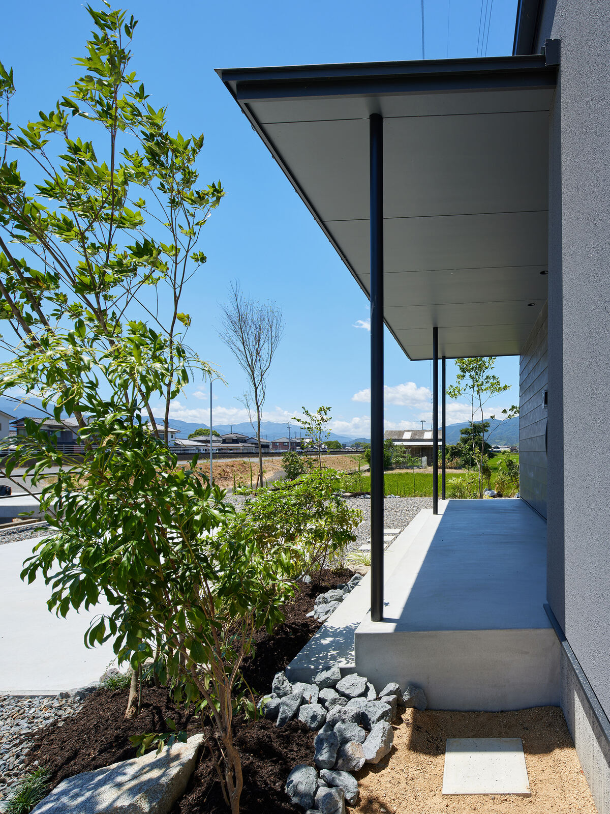軒下の植栽ごしに山並みが見える