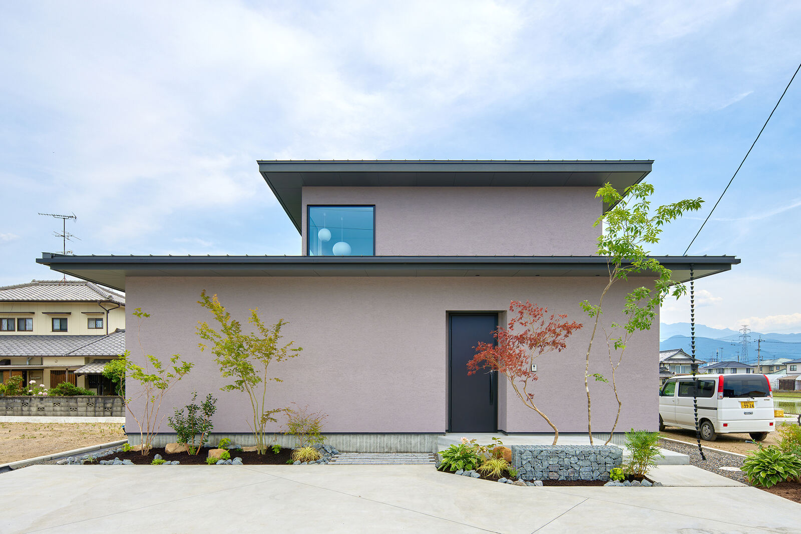 開けた敷地に建つ住宅。奥に山並み