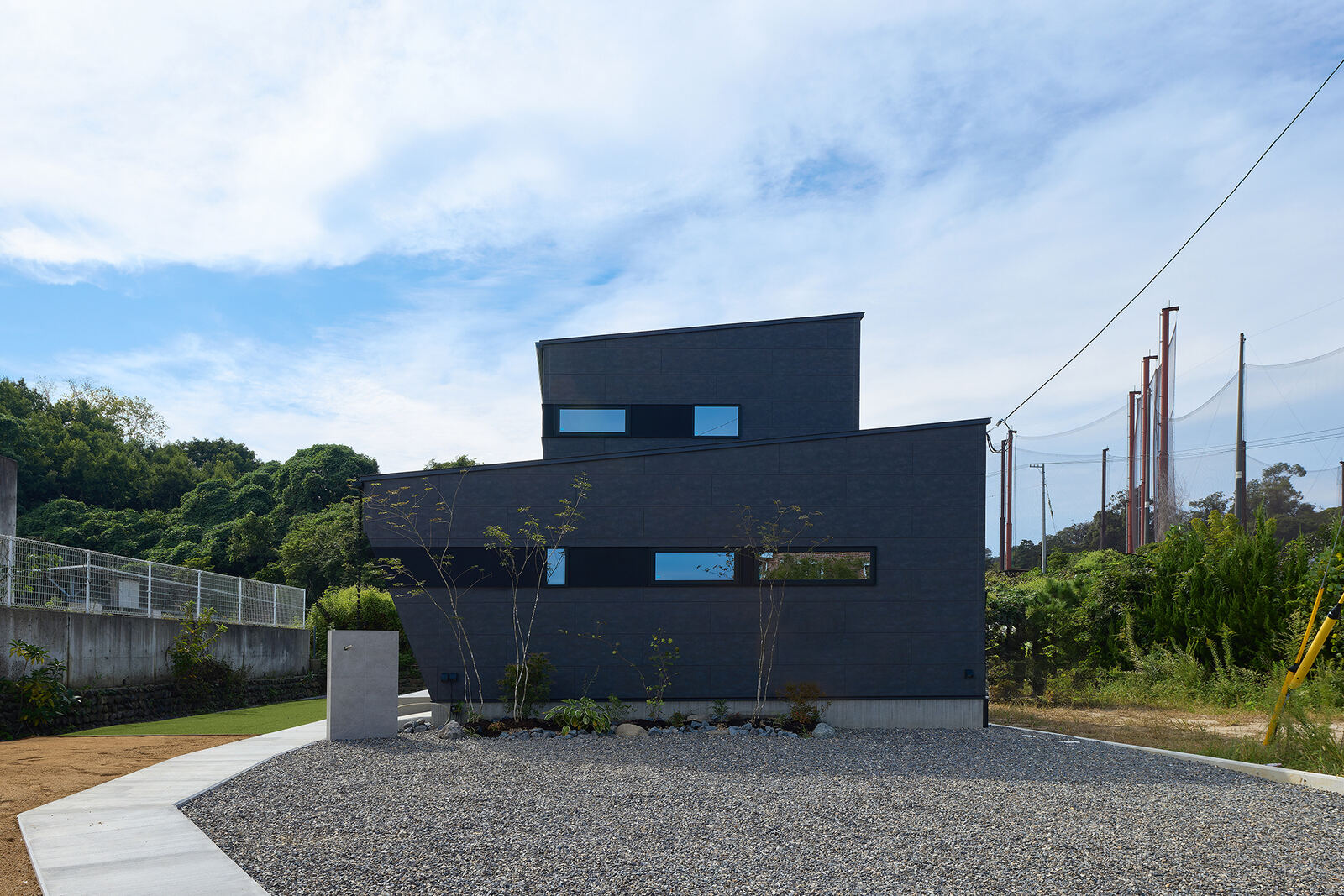 開けた敷地に建つ住宅。奥に山並み
